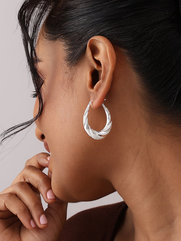 Women wearing Pear shape silver hoops
